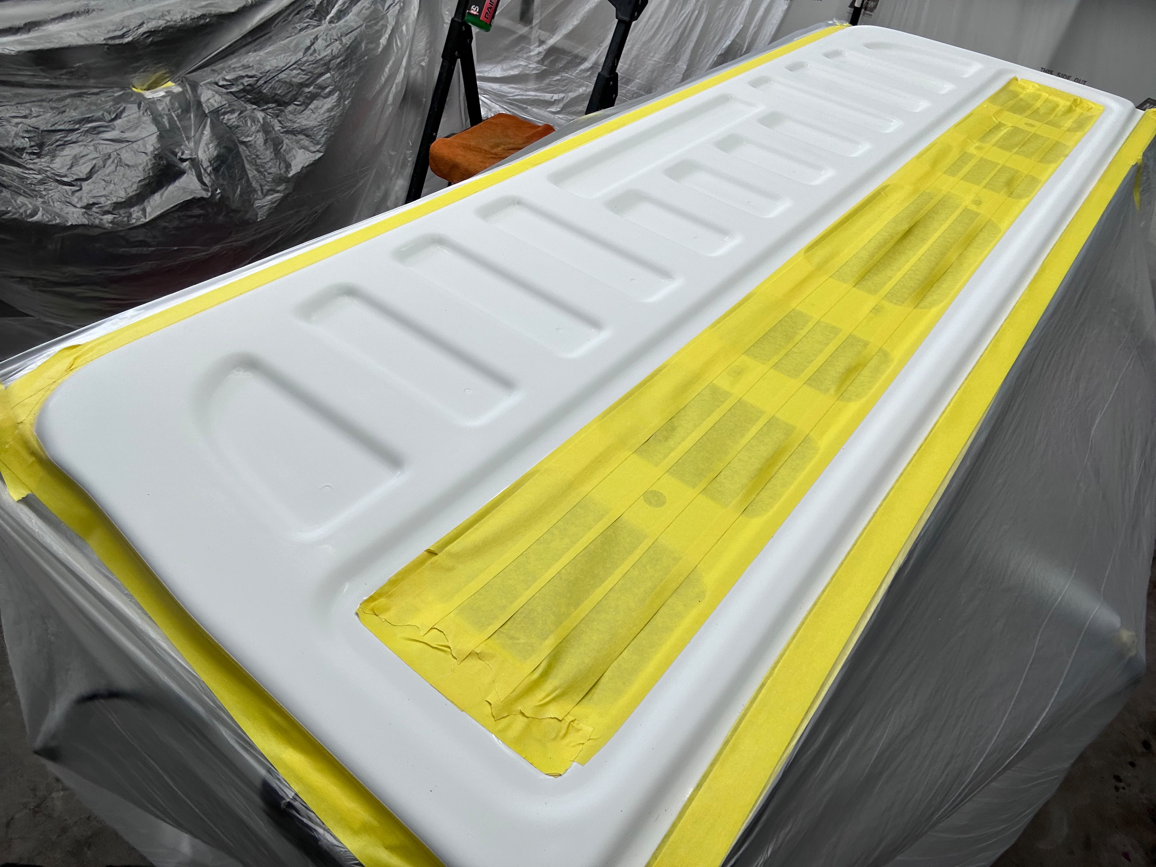 Truck tailgate panel meticulously masked with high-precision yellow tape for bed liner application by Miracle Detailing Lindon UT