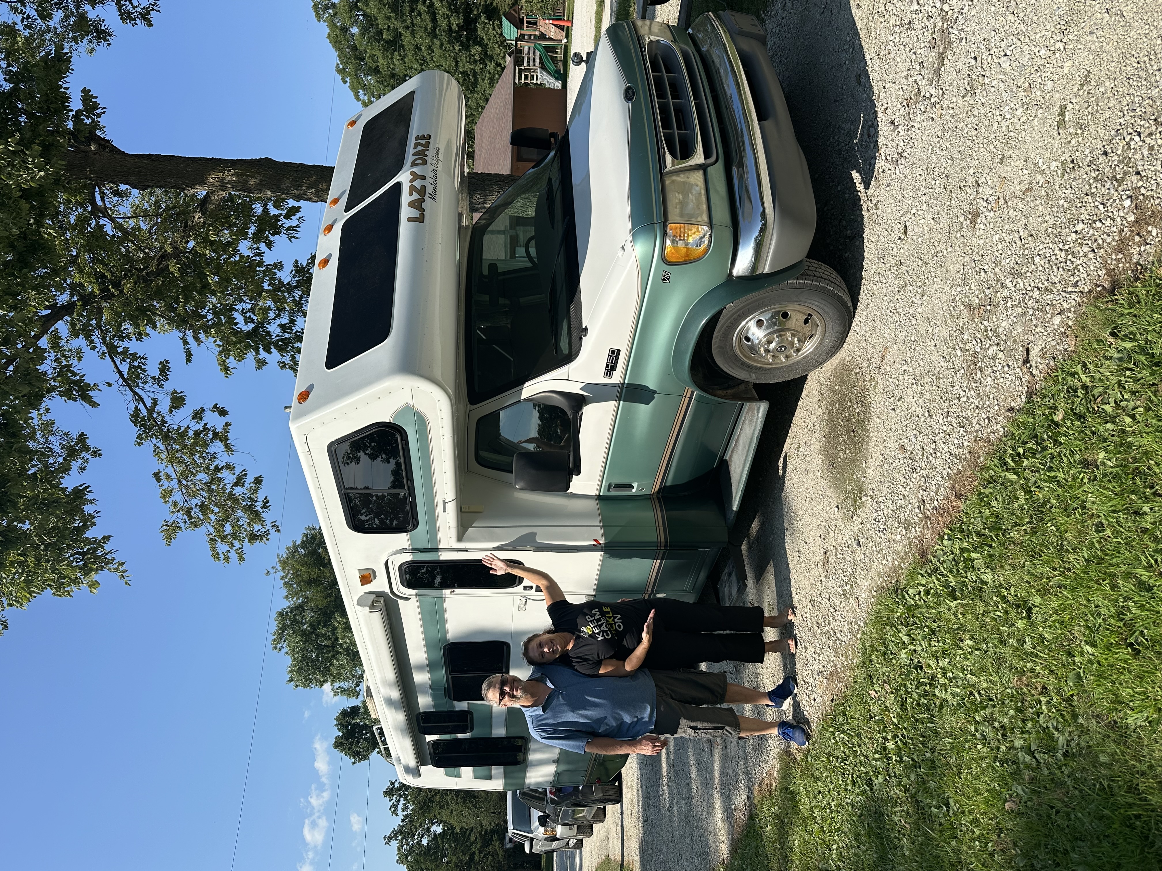 Nikki and Phil smiling proudly next to their vintage 1999 Lazy Daze motorhome Dazey