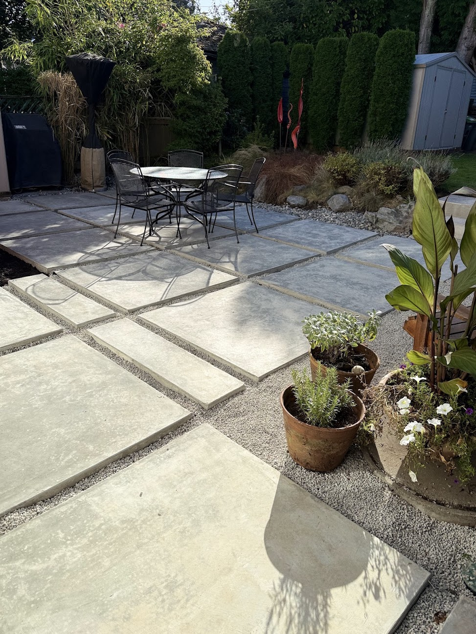 Backyard patio made with large concrete slabs separated by decorative gravel