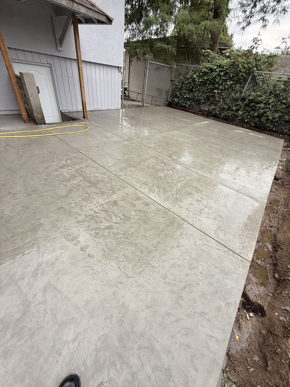 Large textured concrete patio beside a residential home