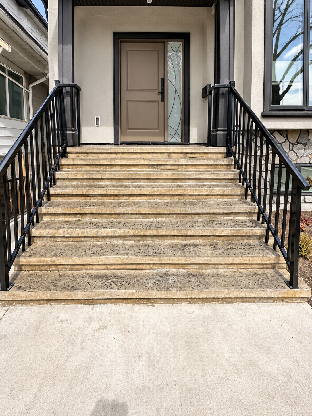 Completed exterior concrete stair system with multiple landings and metal handrails.