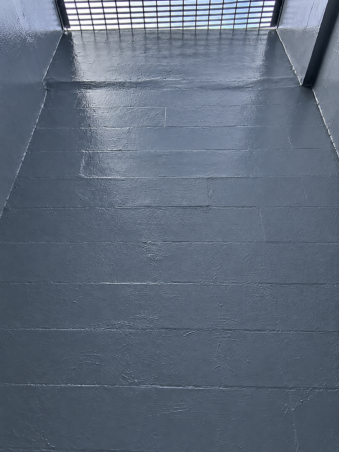 Waterproofing coating applied to concrete walls inside an air-shaft room.