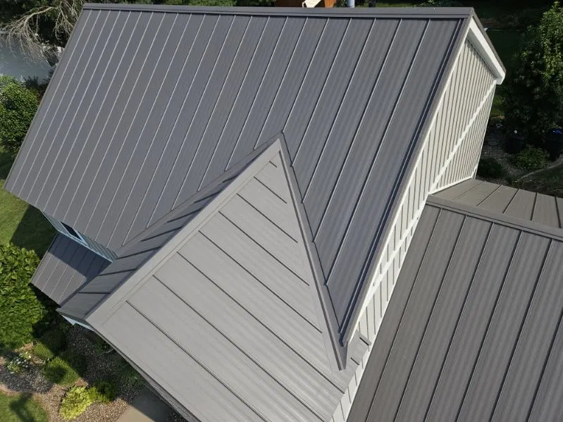 Overhead view of a grey standing seam metal roof showing hips, a valley and a dormer, installed by Snaplock Roofing LLC