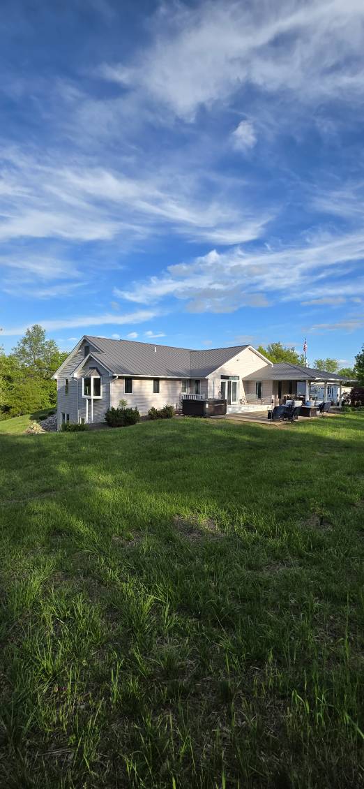 Ranch home with a dark standing seam metal roof under an open Missouri sky, installed by Snaplock Roofing LLC
