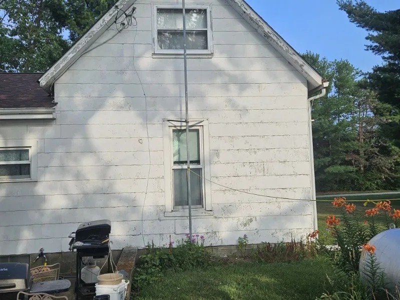 Weathered white farmhouse with an aging shingle roof before a Snaplock Roofing LLC roof replacement