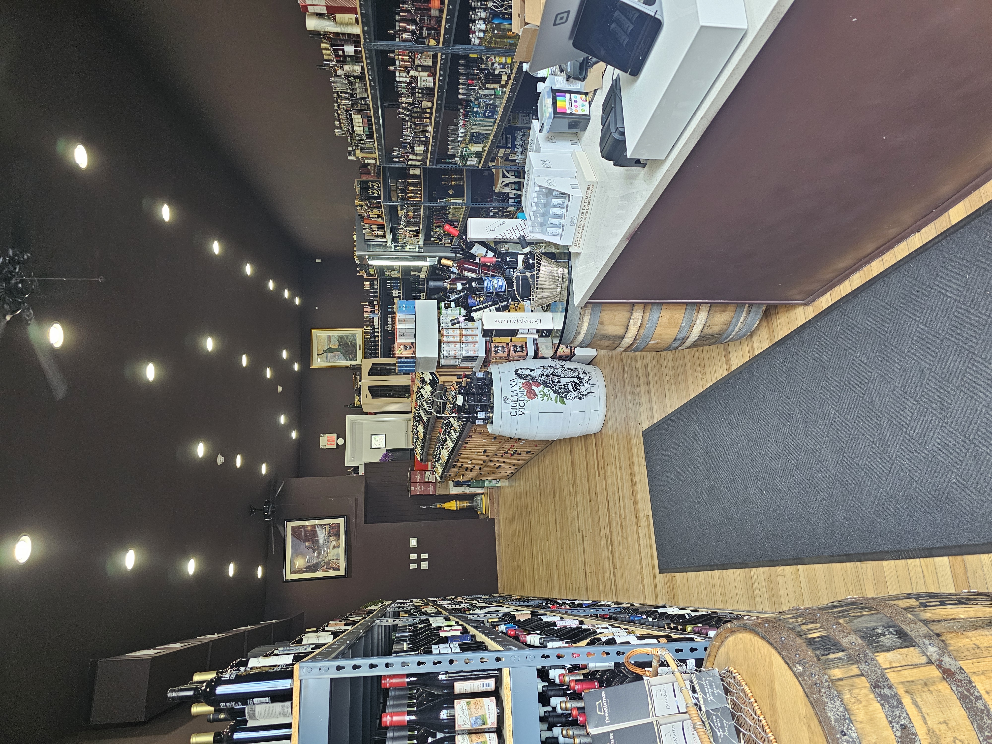 Interior view of Tuckahoe Wine and Spirits featuring checkout counter, wine barrels, and display racks in Tuckahoe NY