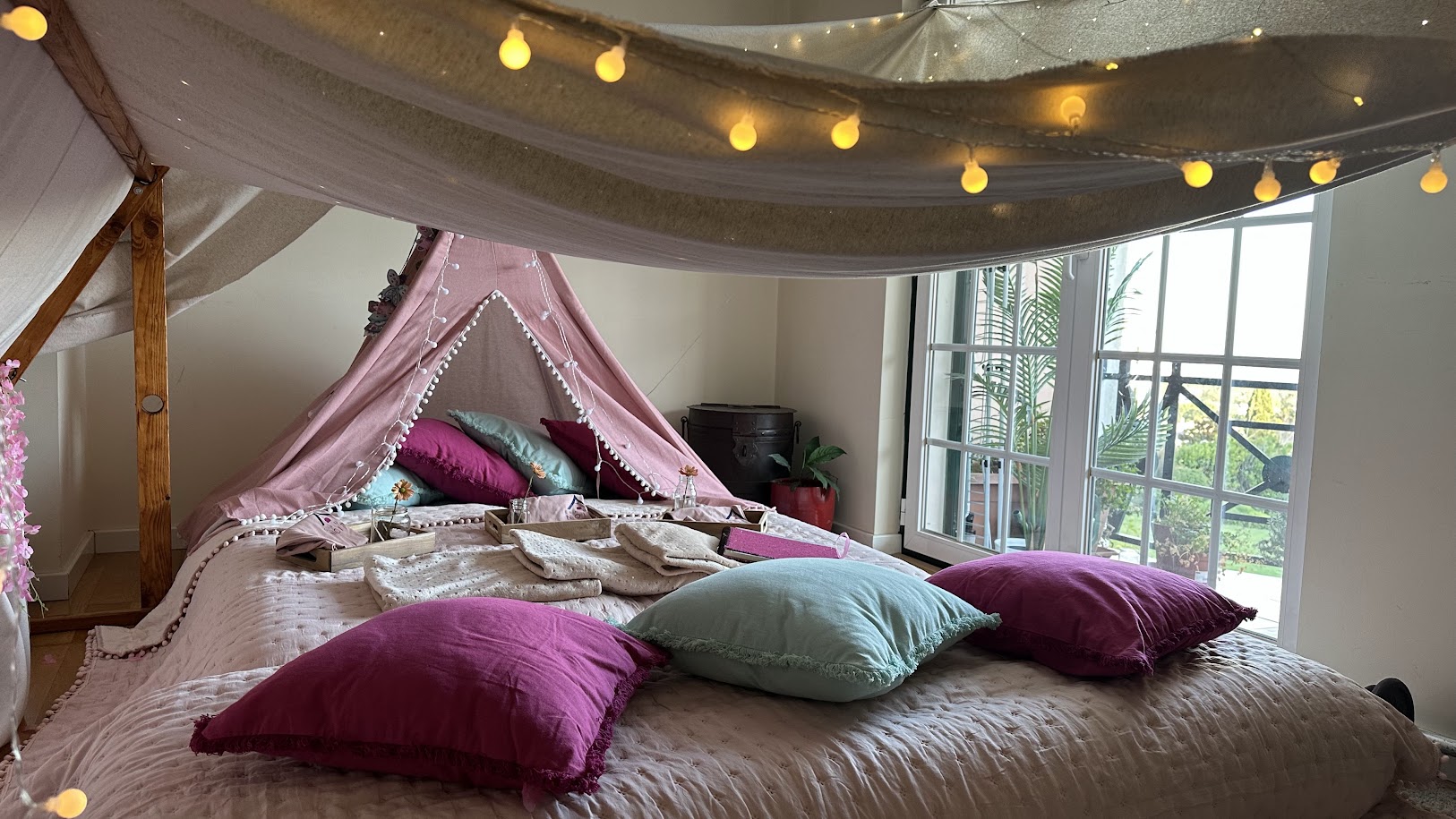 Vista panorâmica da montagem com tenda tipi rosa e luzes quentes