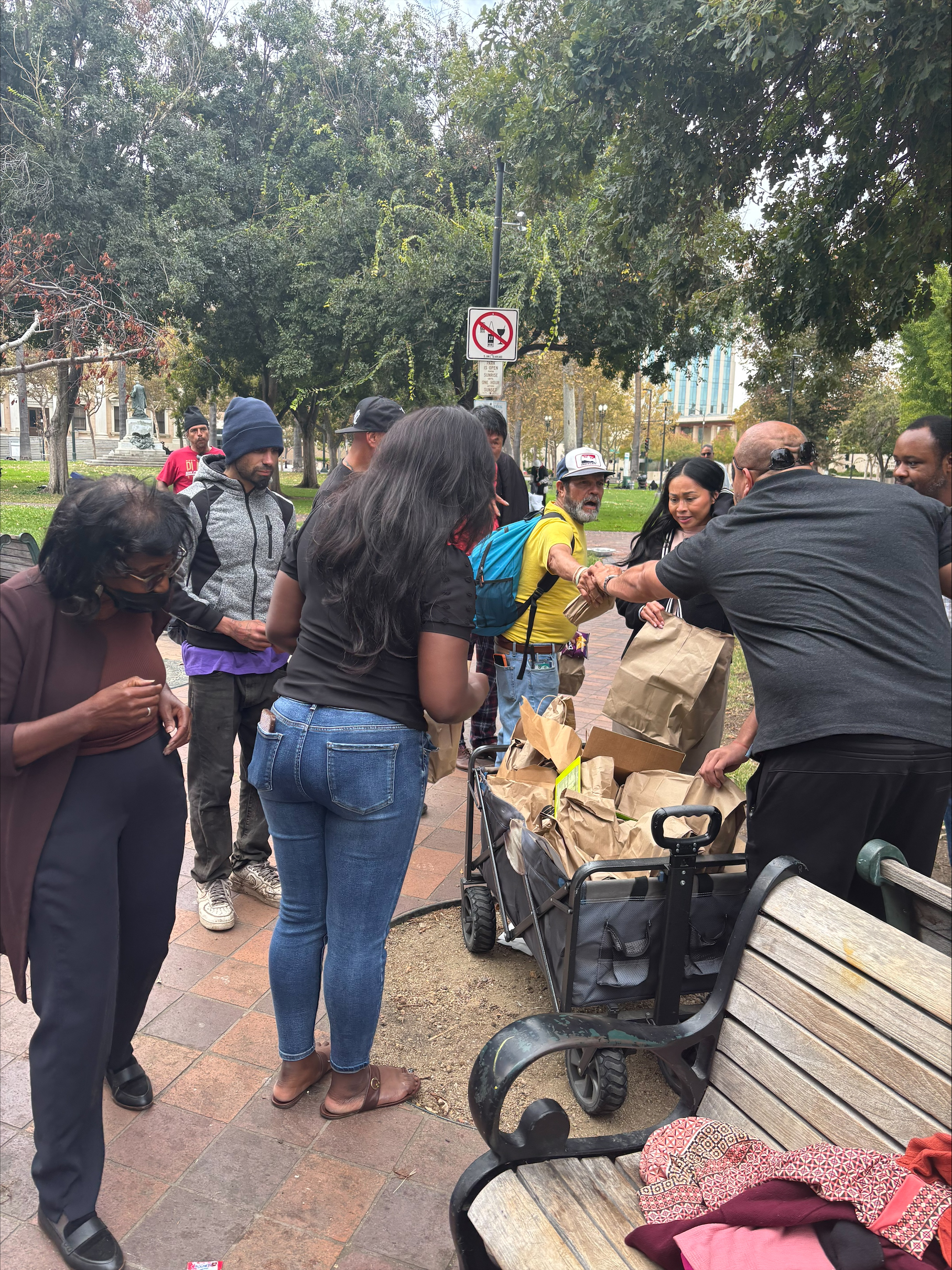 Community members receiving grocery care packages in the park