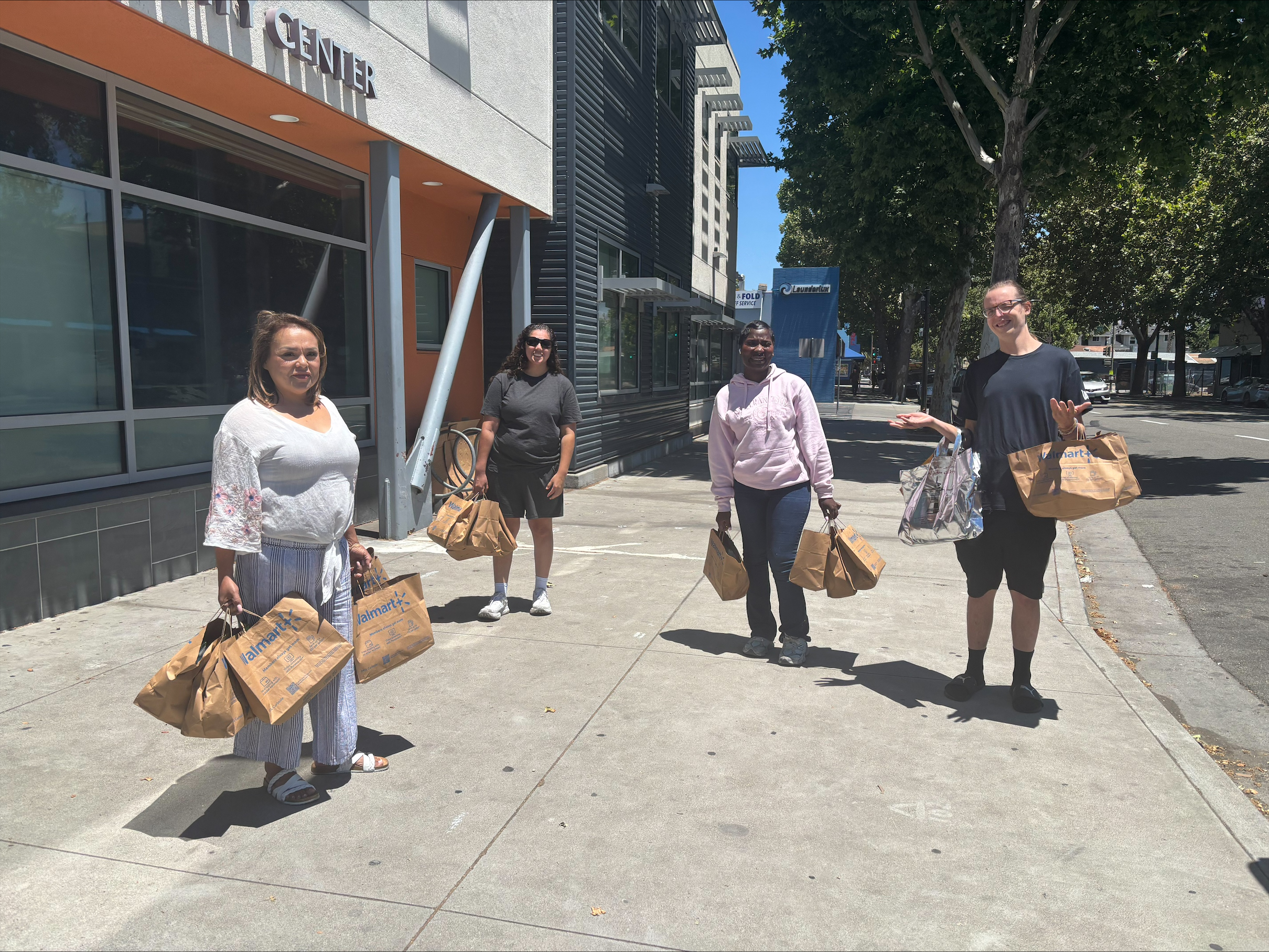 Volunteers carrying bags of groceries outside the center for distribution