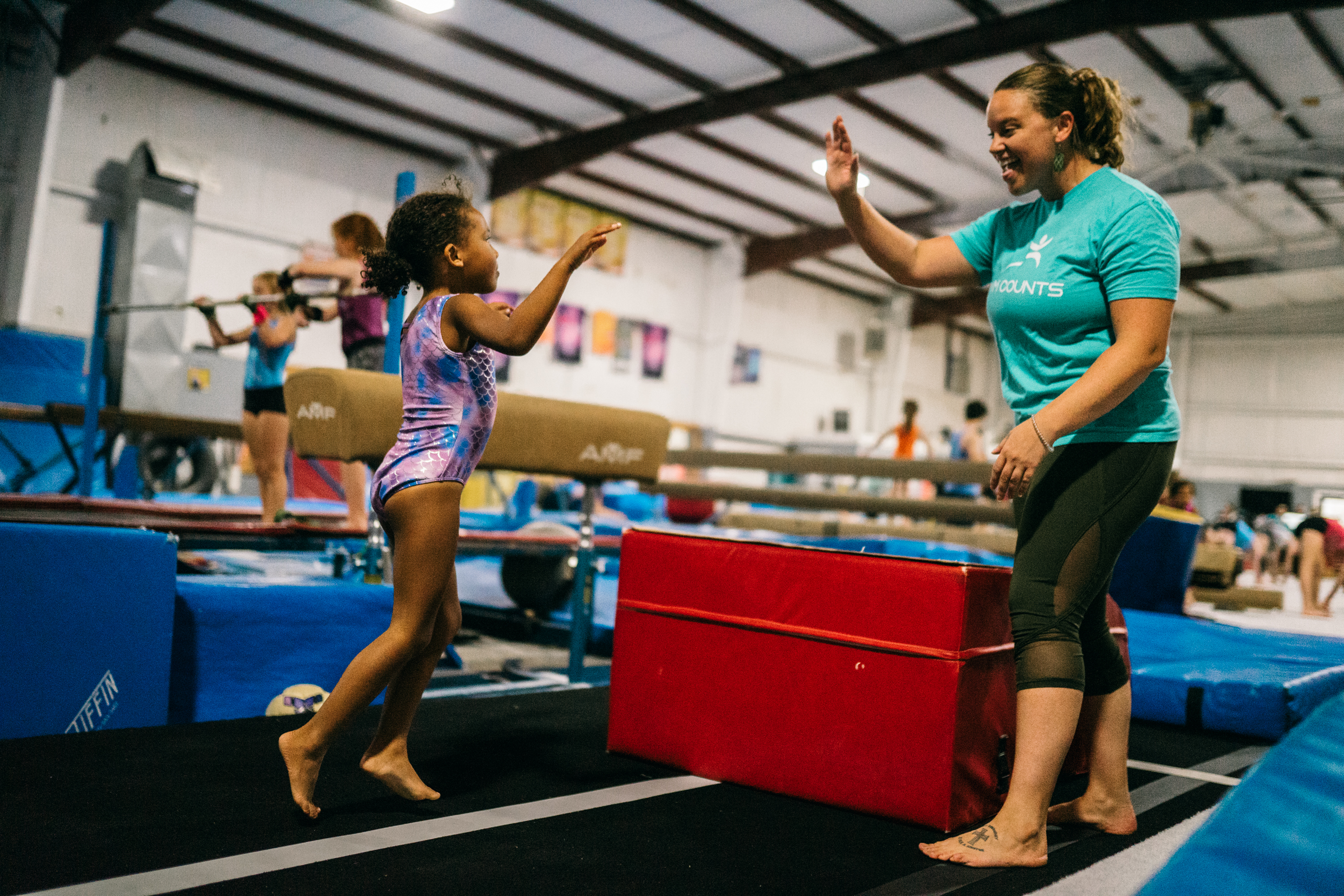 A Gym Counts coach guiding a group of young athletes during practice