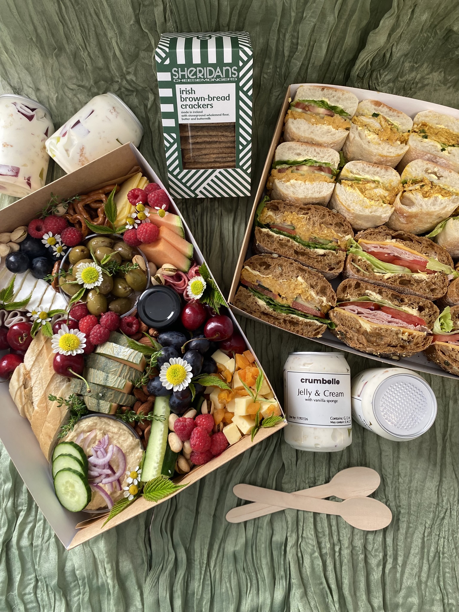 Complete crumbelle catering spread with grazing box, sandwich platter, Sheridan's crackers and branded dessert jars