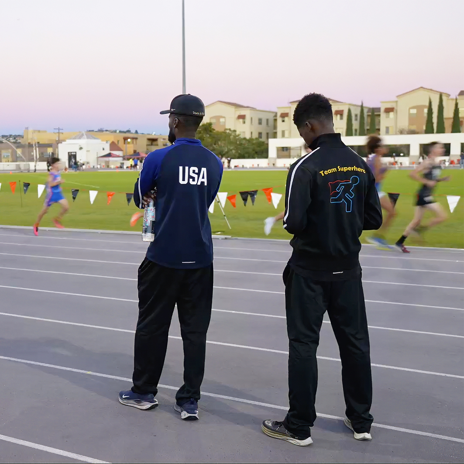 Coach Ken Nwadike Jr. trackside mentoring athletes