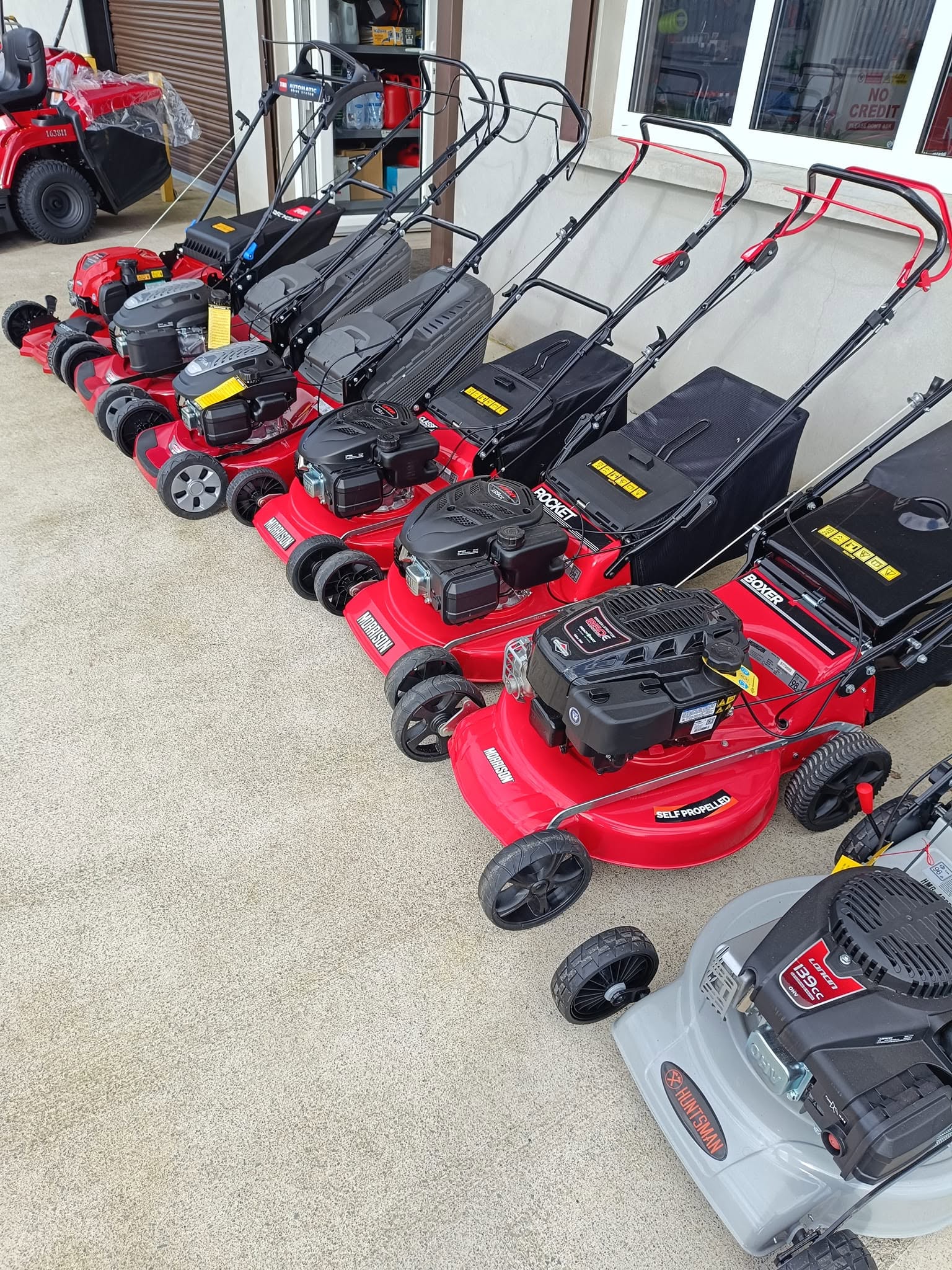RM Lawnmowers shopfront with lawnmower display and opening hours, Meath