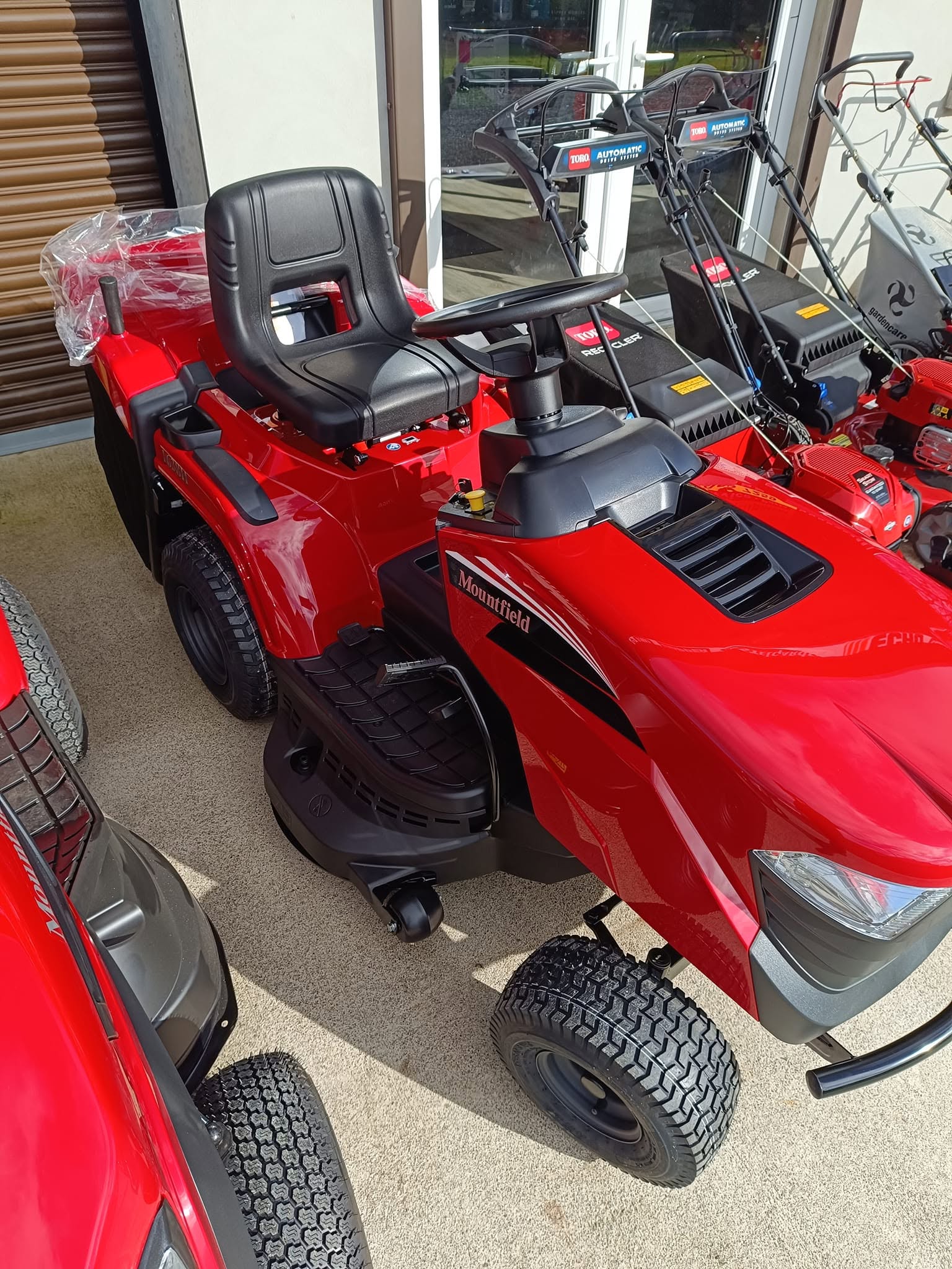 Mountfield ride-on lawn tractor outside shop display alongside Toro mowers