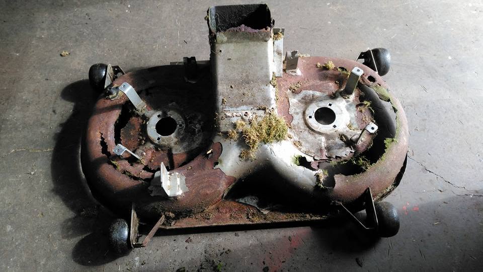 Corroded ride-on mower cutting deck assessment before welding repair or replacement