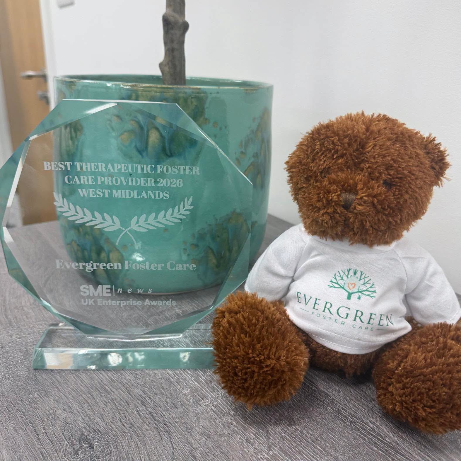 Evergreen Foster Care award trophy alongside the Evergreen teddy bear
