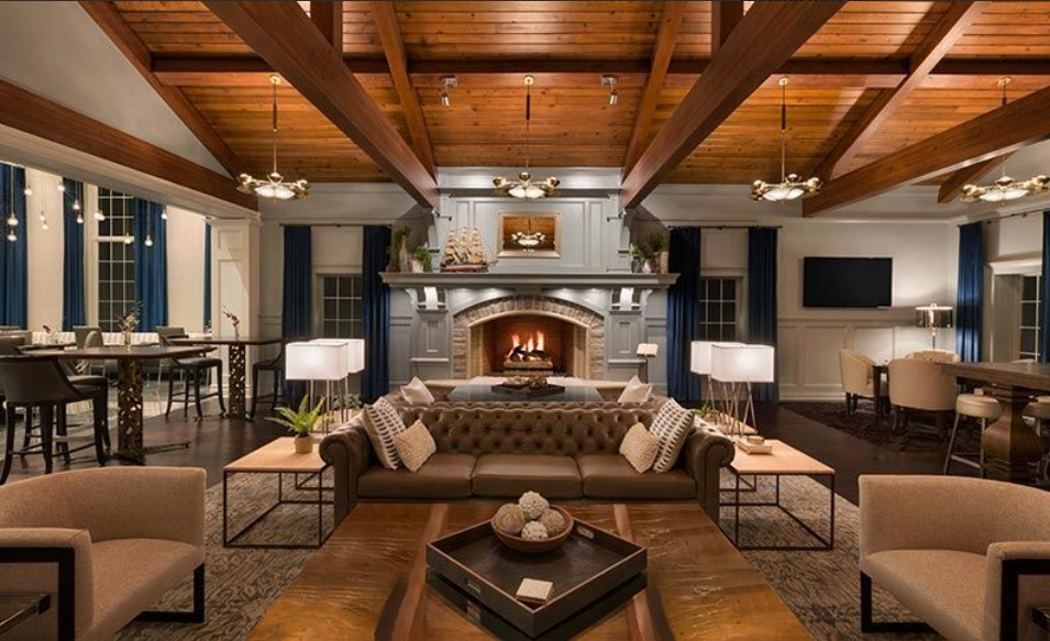 Reikart House fireside lounge with leather seating, fireplace, and timber-beamed ceiling