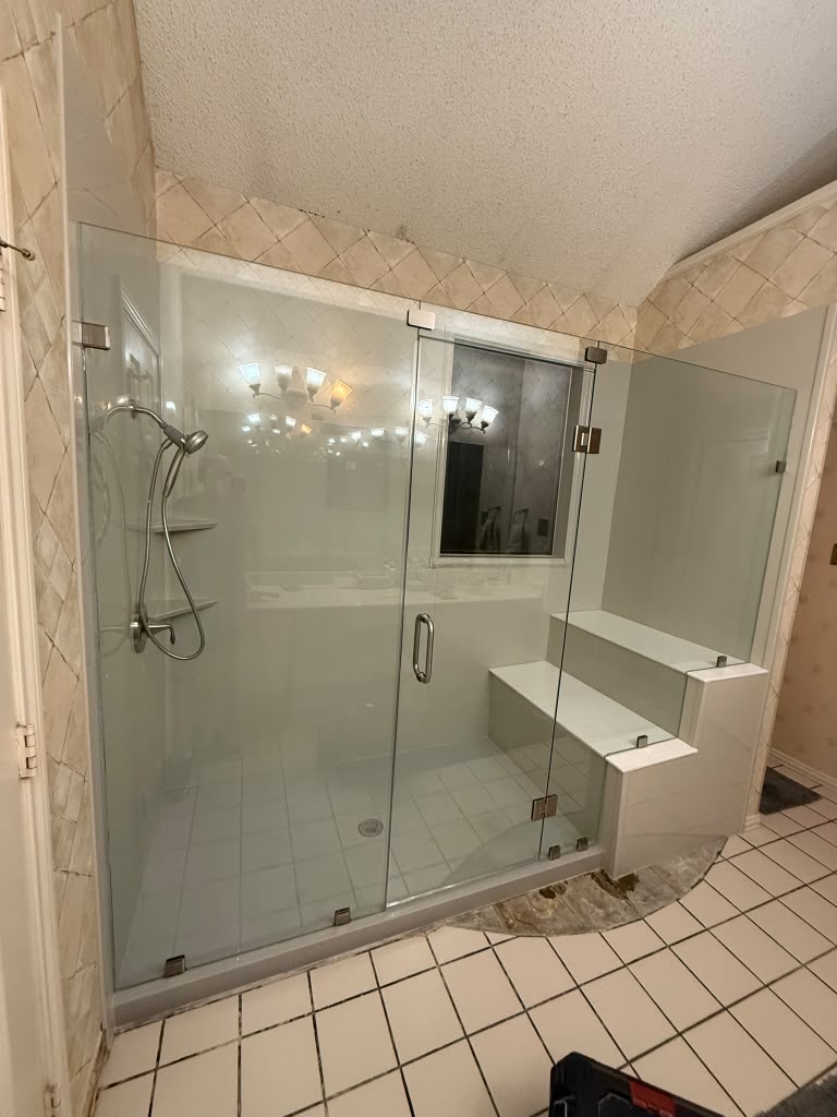Frameless glass shower enclosure with built-in bench seat