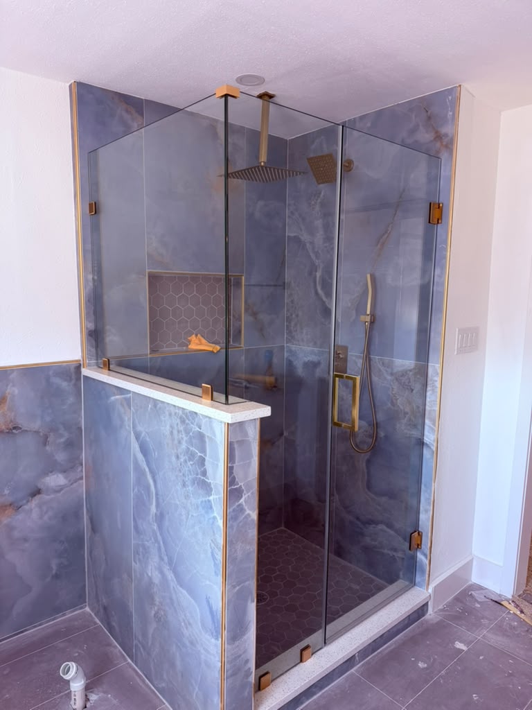 Luxury blue marble shower enclosure with pony wall and brushed brass hardware