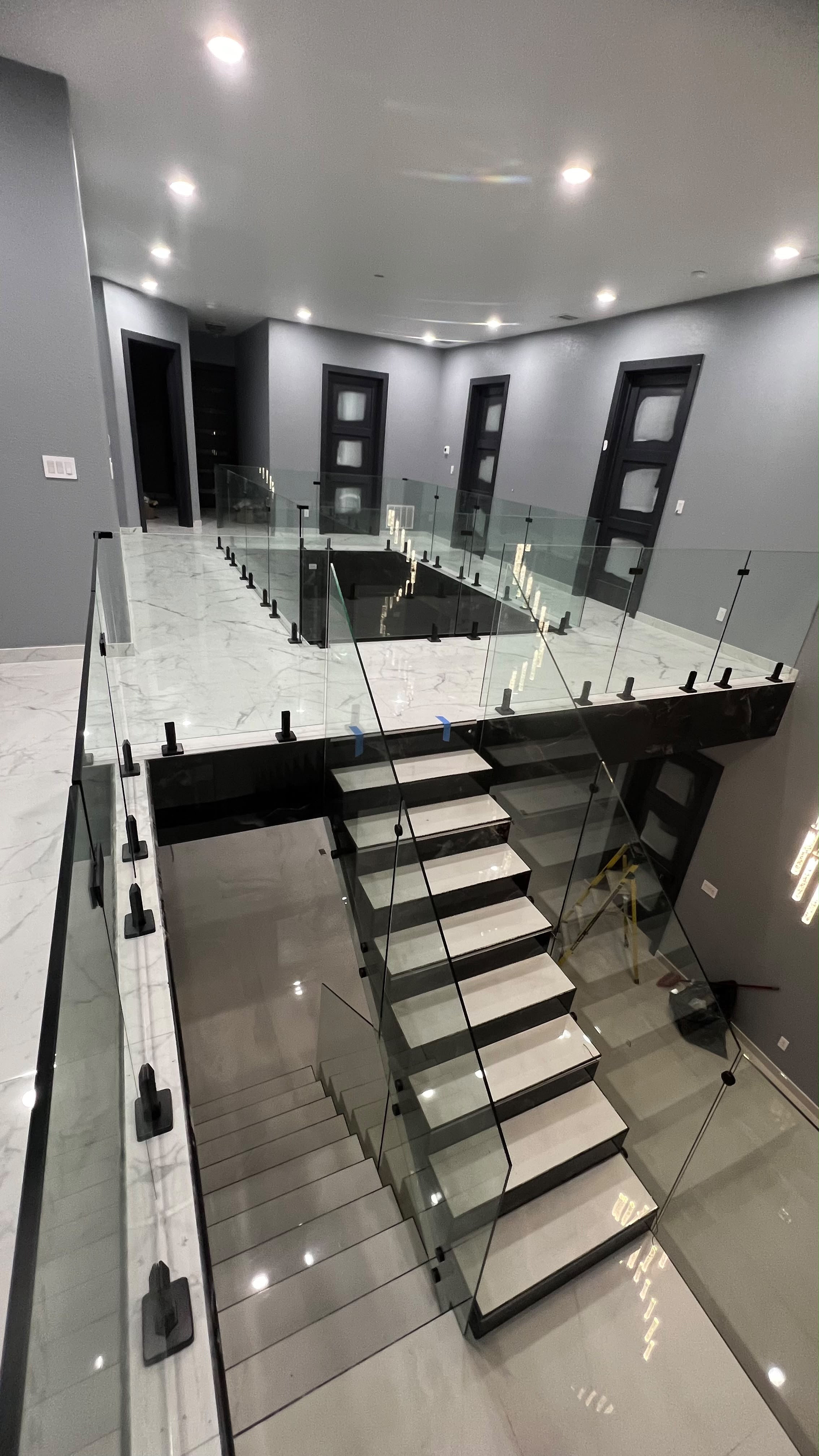 Modern frameless glass stair and mezzanine railing with black spigots