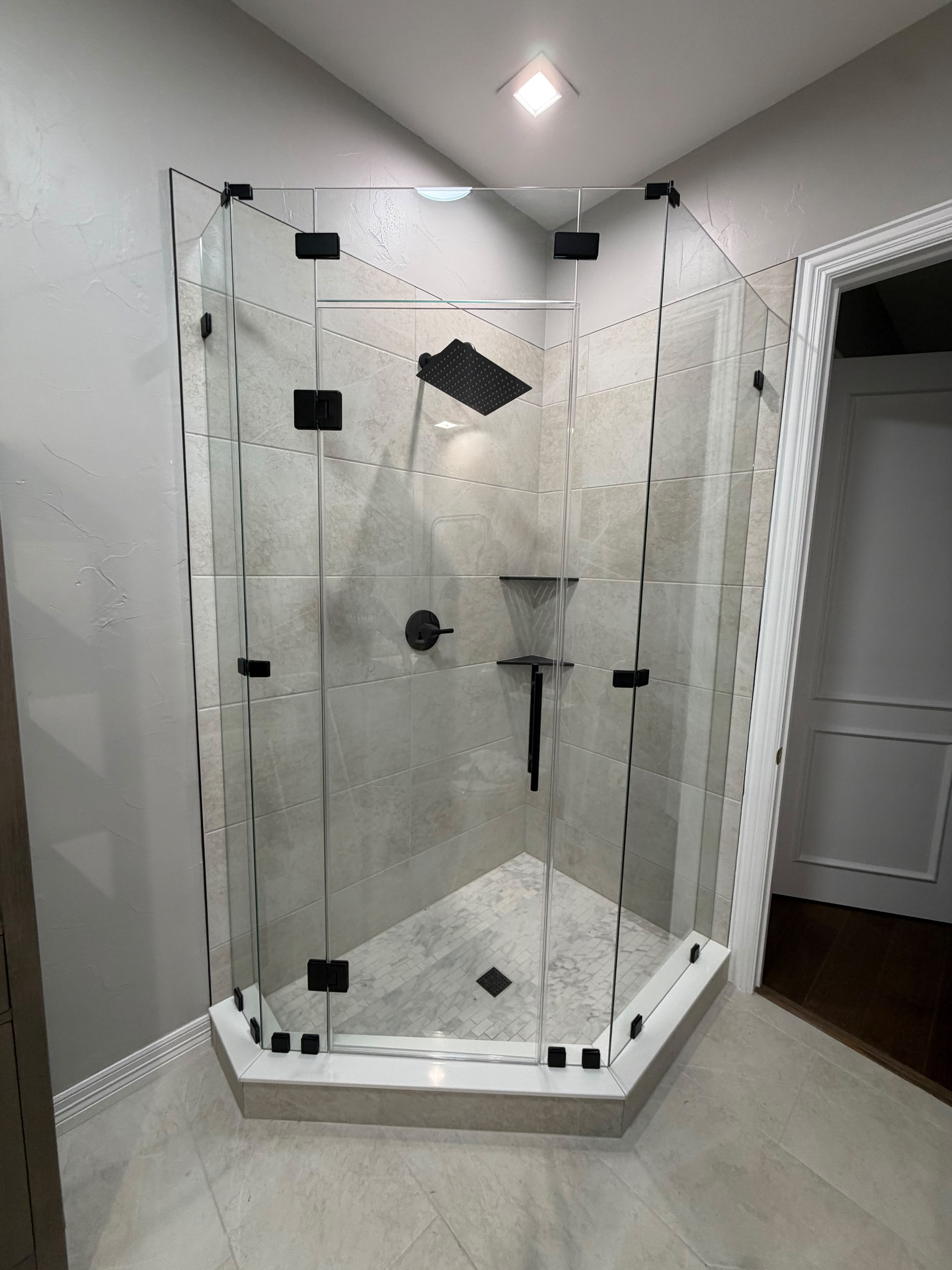 Custom neo-angle corner glass shower enclosure with matte black clips