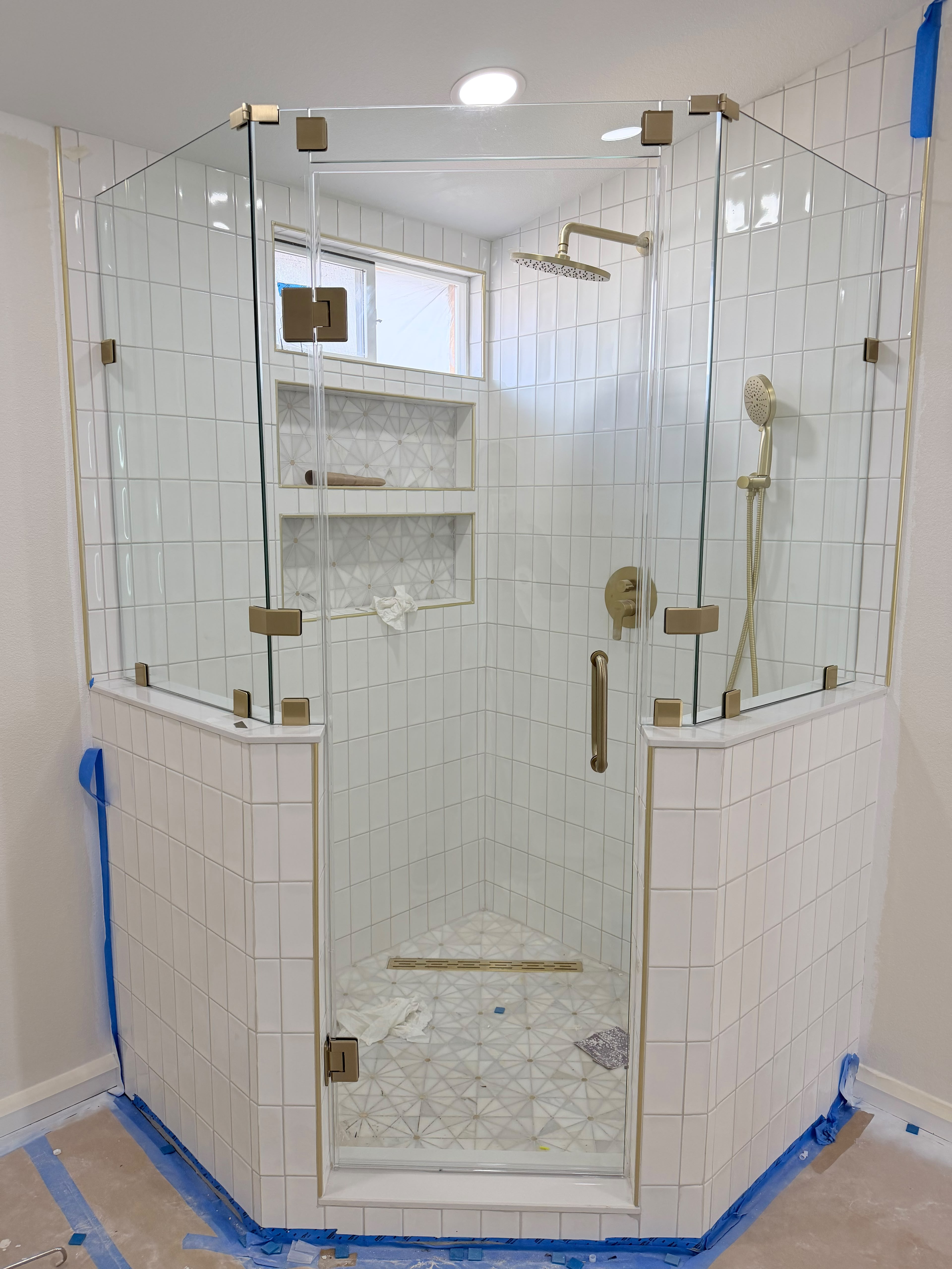 Custom corner frameless shower enclosure with brushed brass hardware