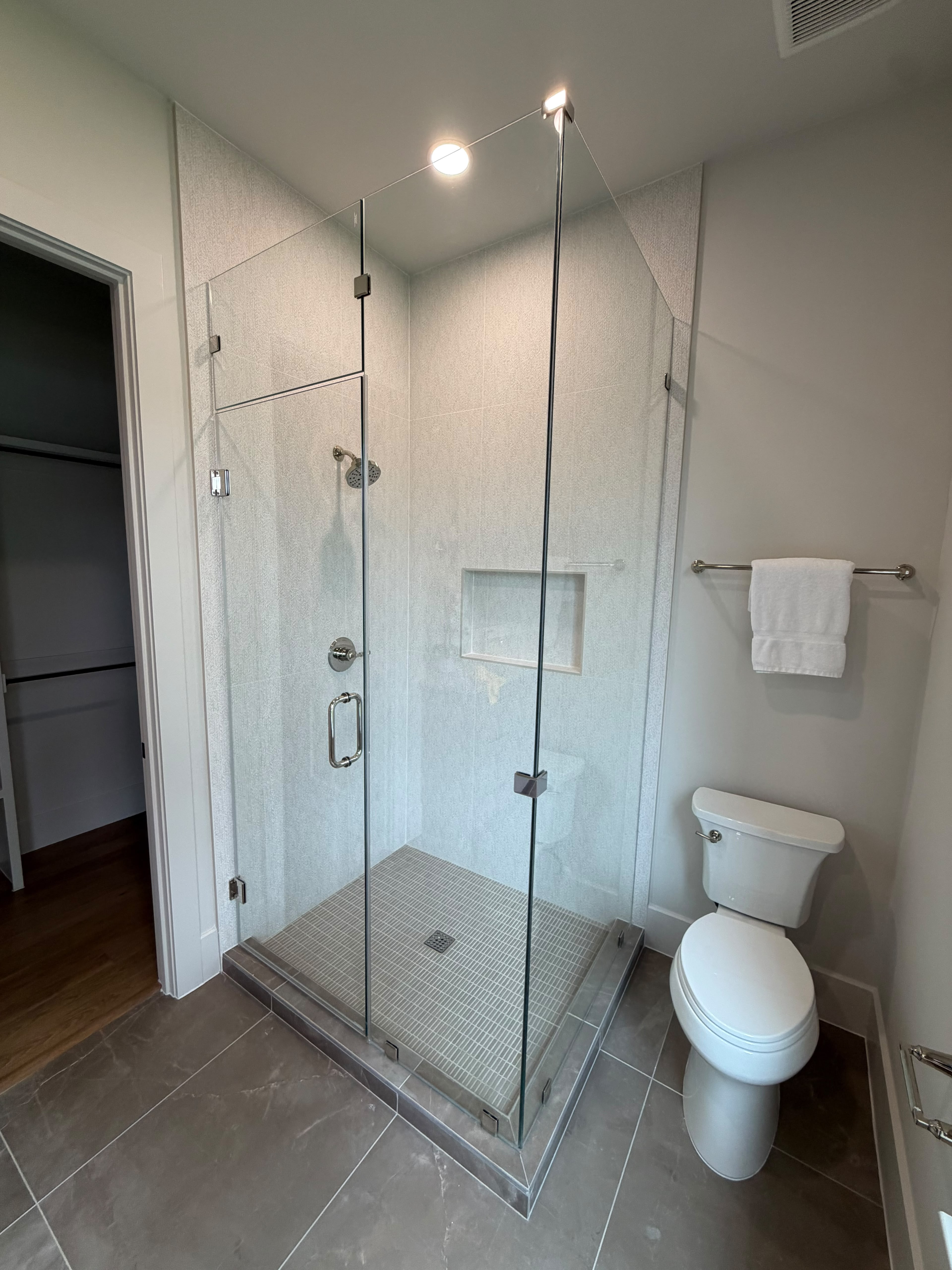 Custom corner glass shower enclosure with chrome hardware