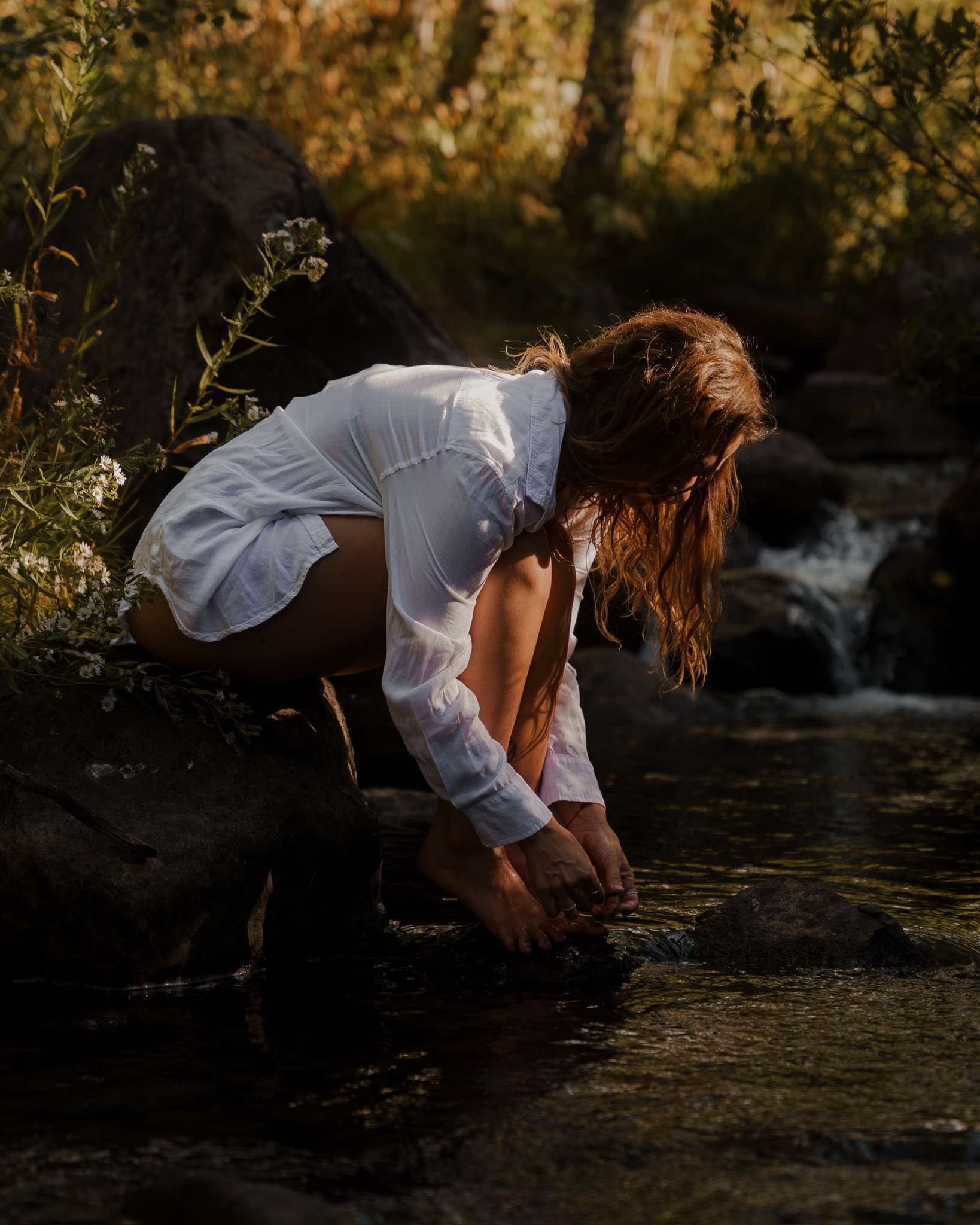 Shawnee touching water in a natural stream, connecting with instinct