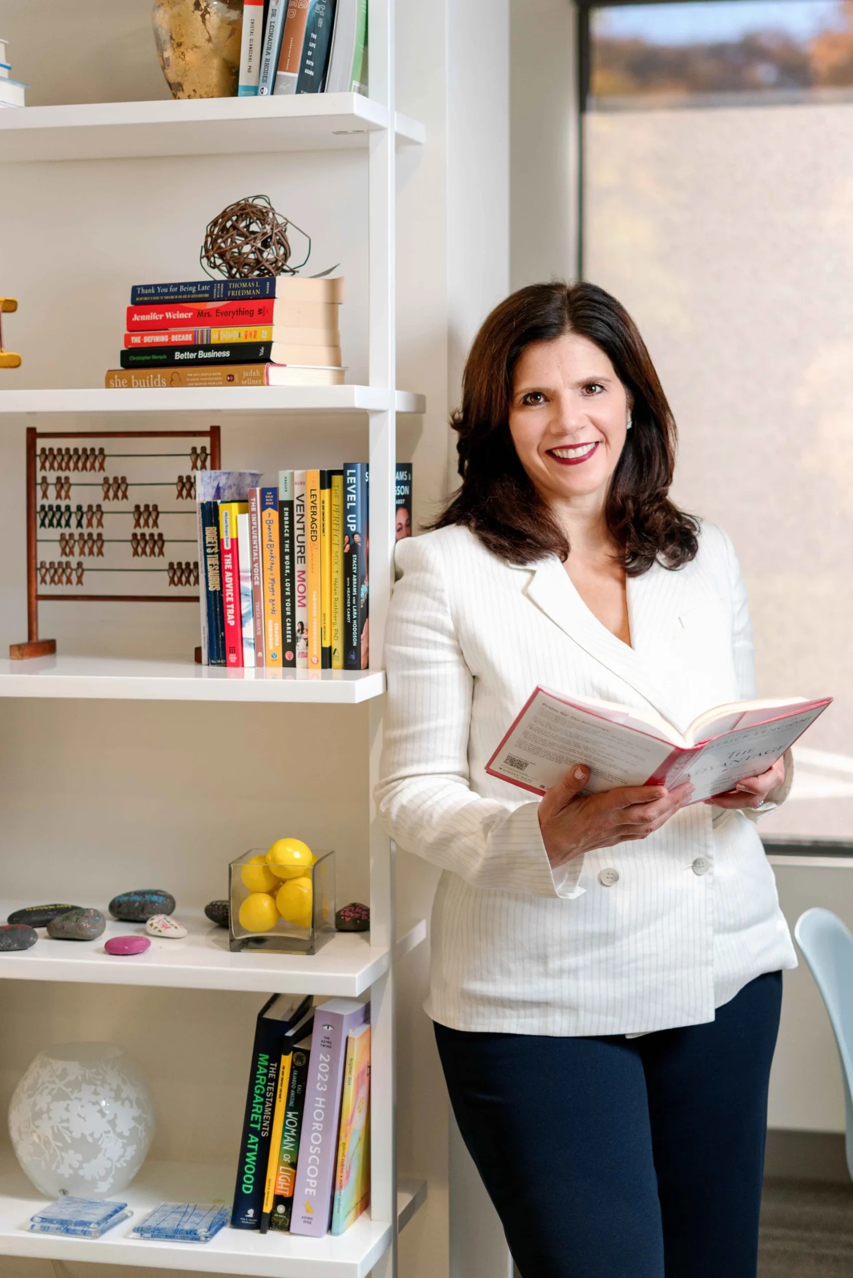 Author and business leader with book by an executive bookshelf
