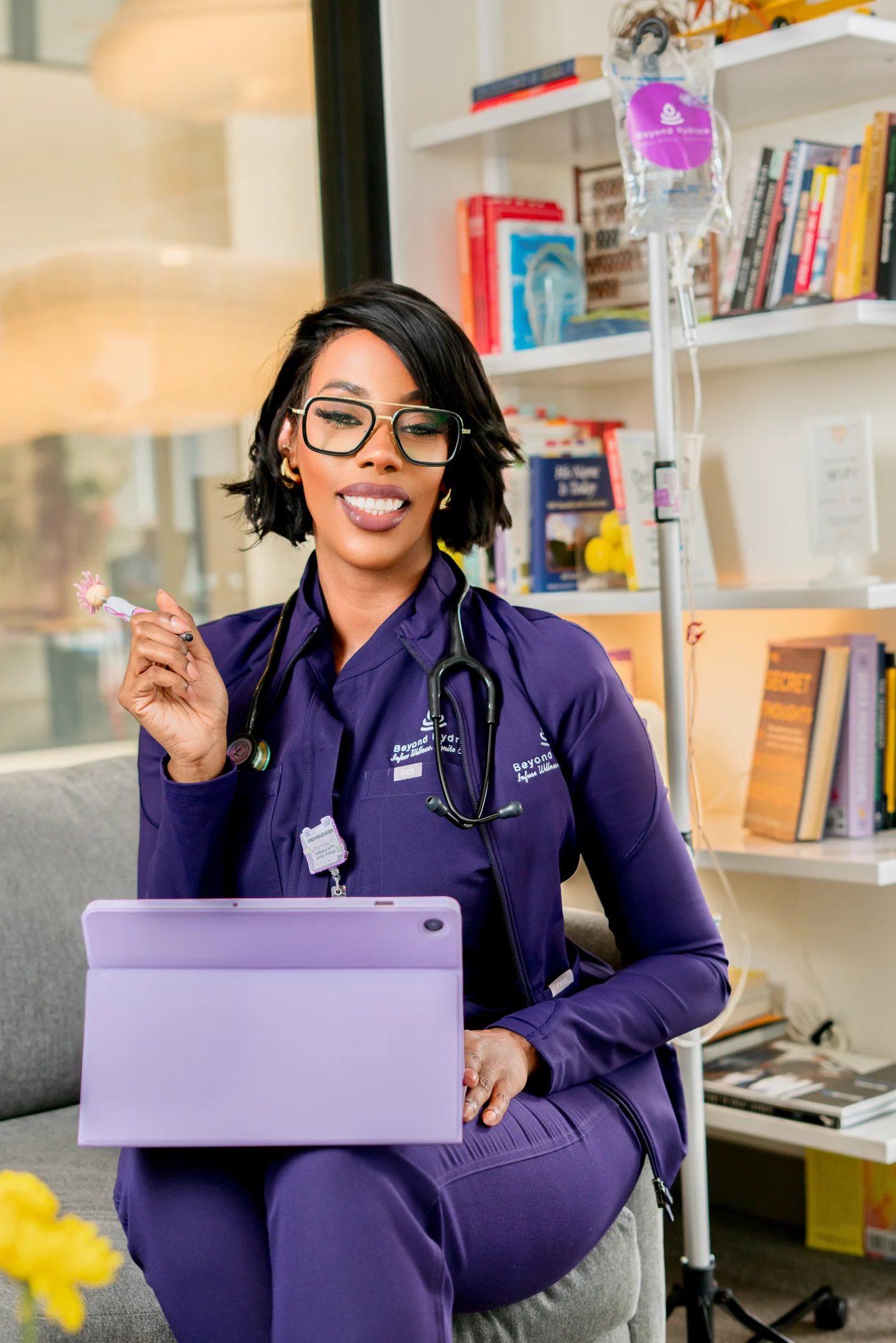 Healthcare and wellness founder in medical scrub with tablet and infusion setup
