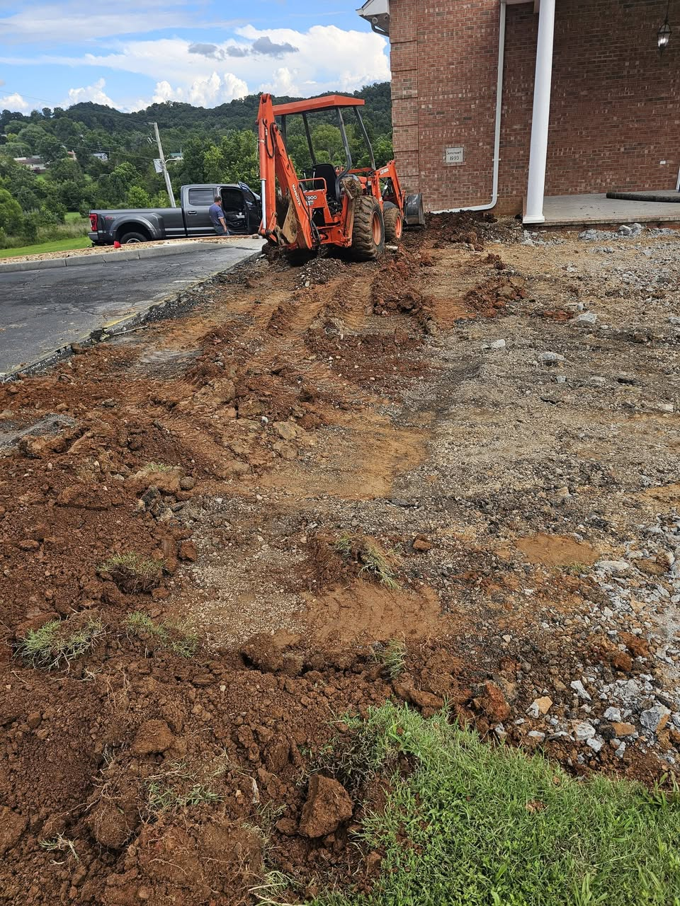 Excavator digging trench for new water line at Emmaus Church in Kingsport, TN