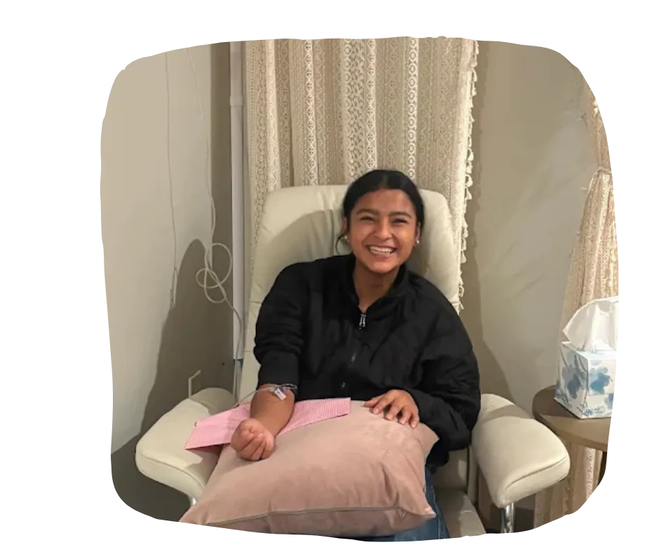 Client smiling and comfortably receiving an IV hydration infusion at Aspiral Healing