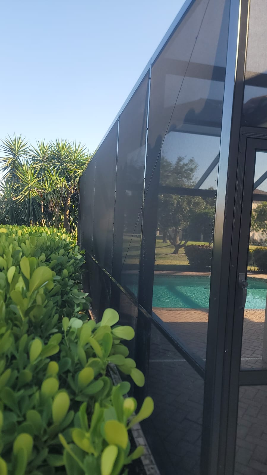 Exterior structural aluminum screen framing, heavy-duty door and clean lines on an Excel Exteriors build in Southwest Florida