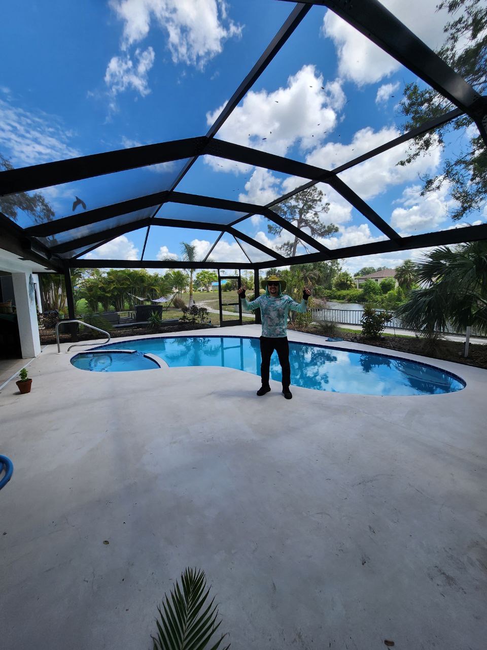 Custom soaring pool screen enclosure over pool in Southwest Florida with bright blue sky