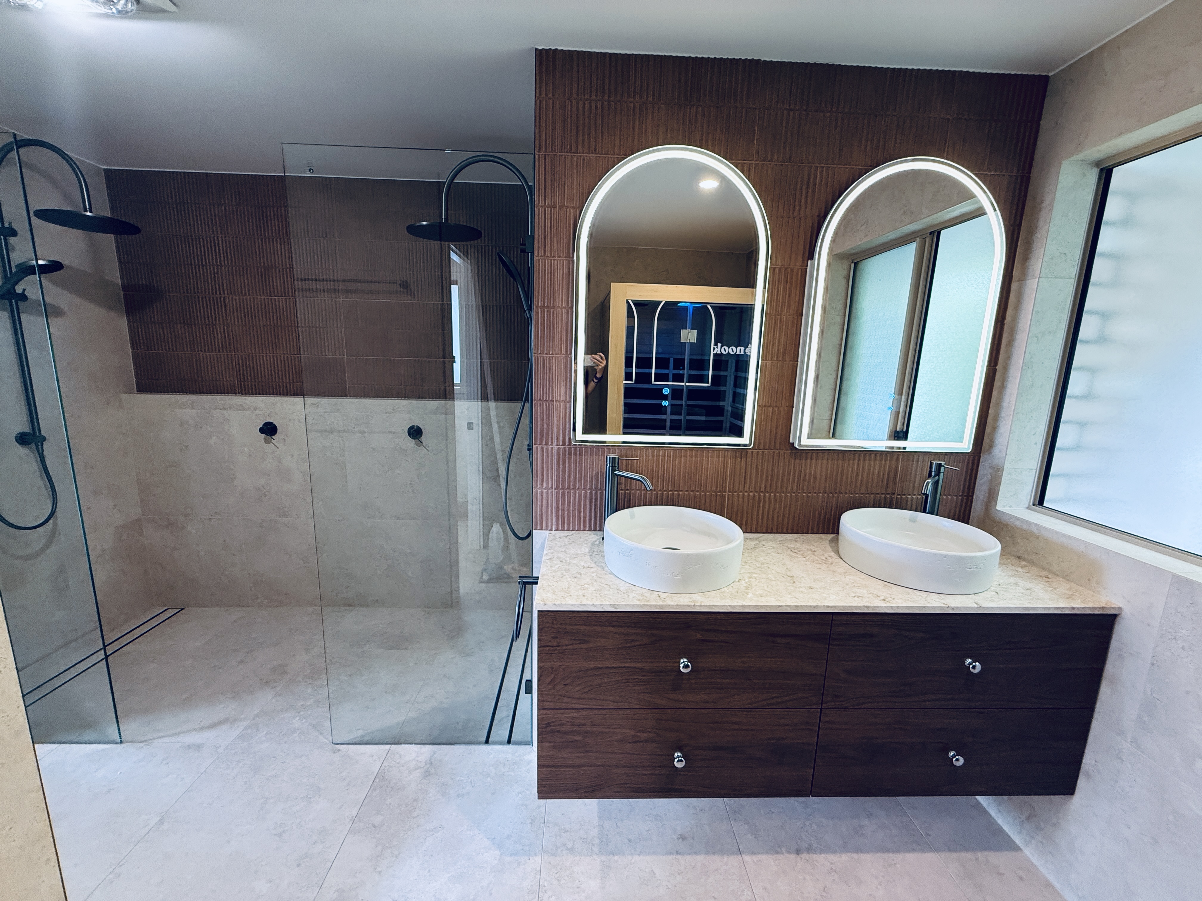 Luxury master bathroom suite with double shower, linear drain, arched vanities and fluted tilework