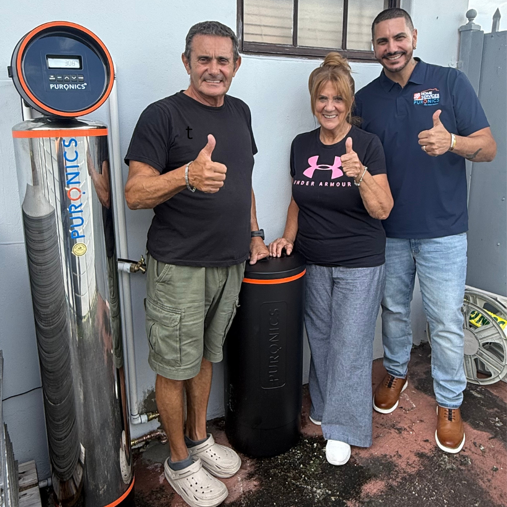 Ameritek Corpus Christi technician with happy homeowners beside a newly installed Puronics water treatment system