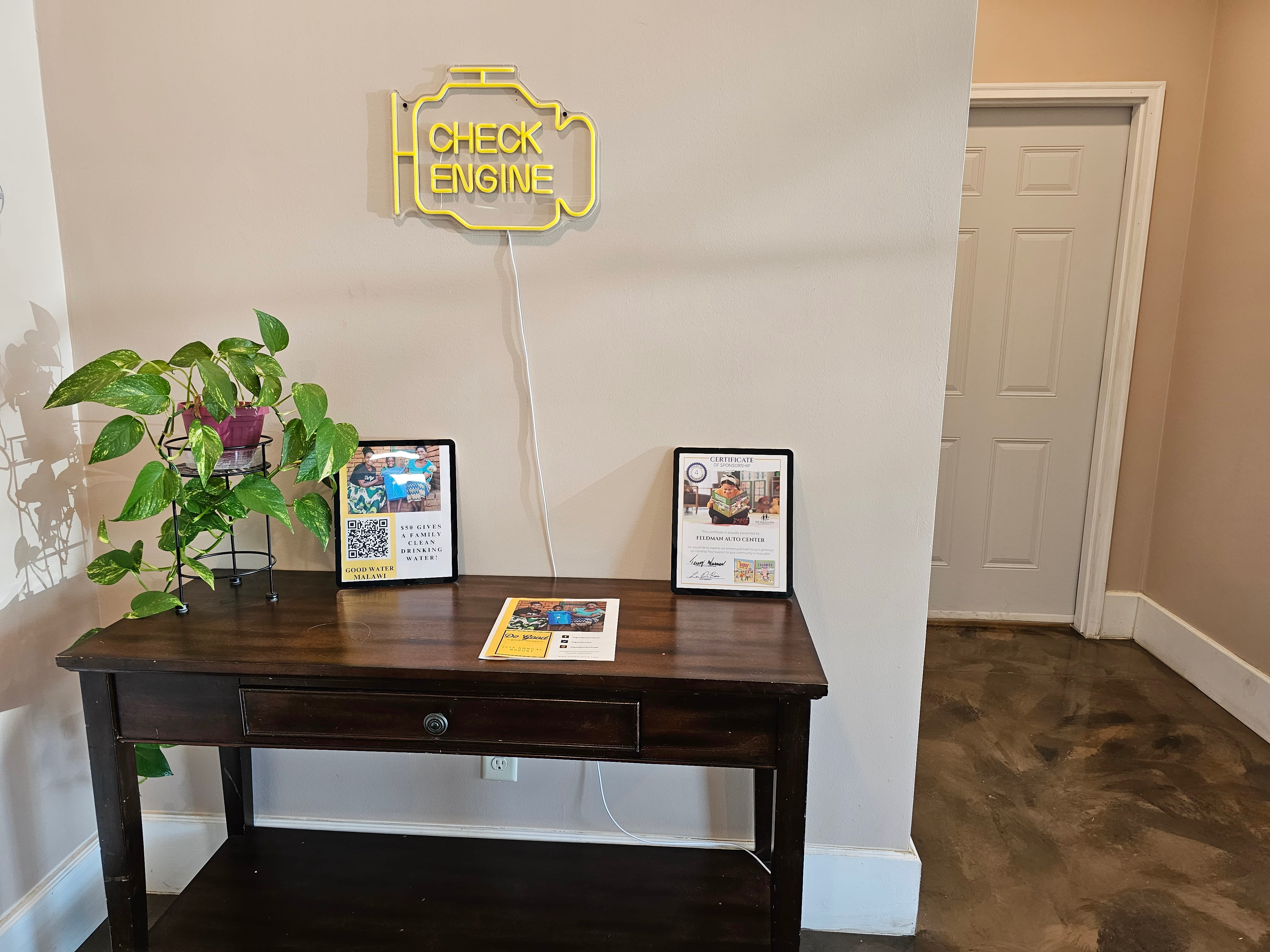 Check engine neon sign and community giving in customer lobby