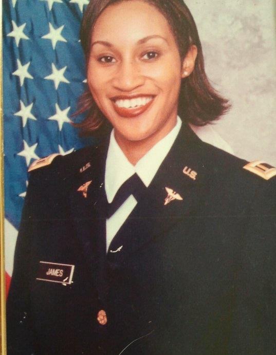 Archival portrait supplied by Michelle showing her in Army uniform beside a U.S. flag.