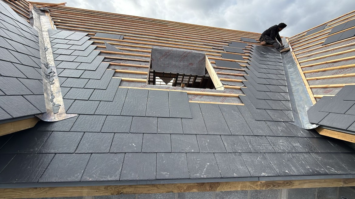 During: Installing premium slates around the custom Velux rooflight opening and lead-lined valley.