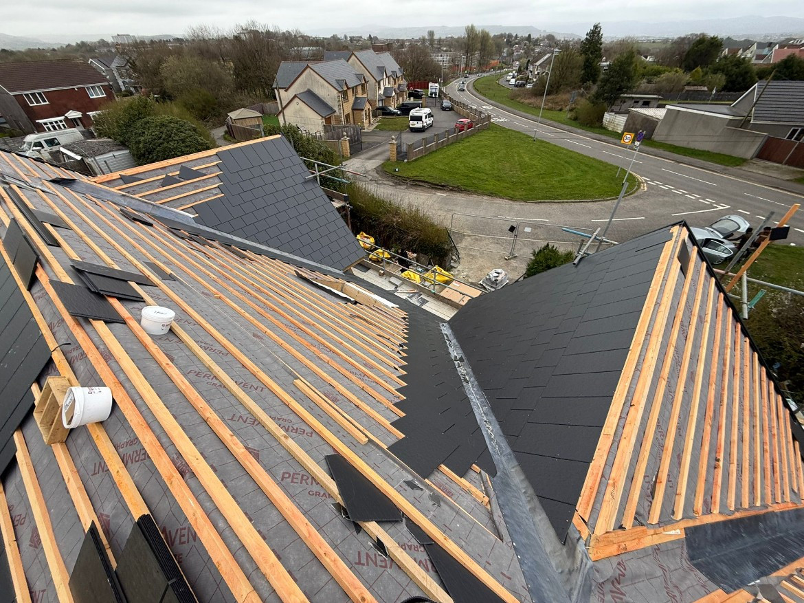 During: High-angle view showing treated timber battens, breathable membrane, and precision lead valley construction.