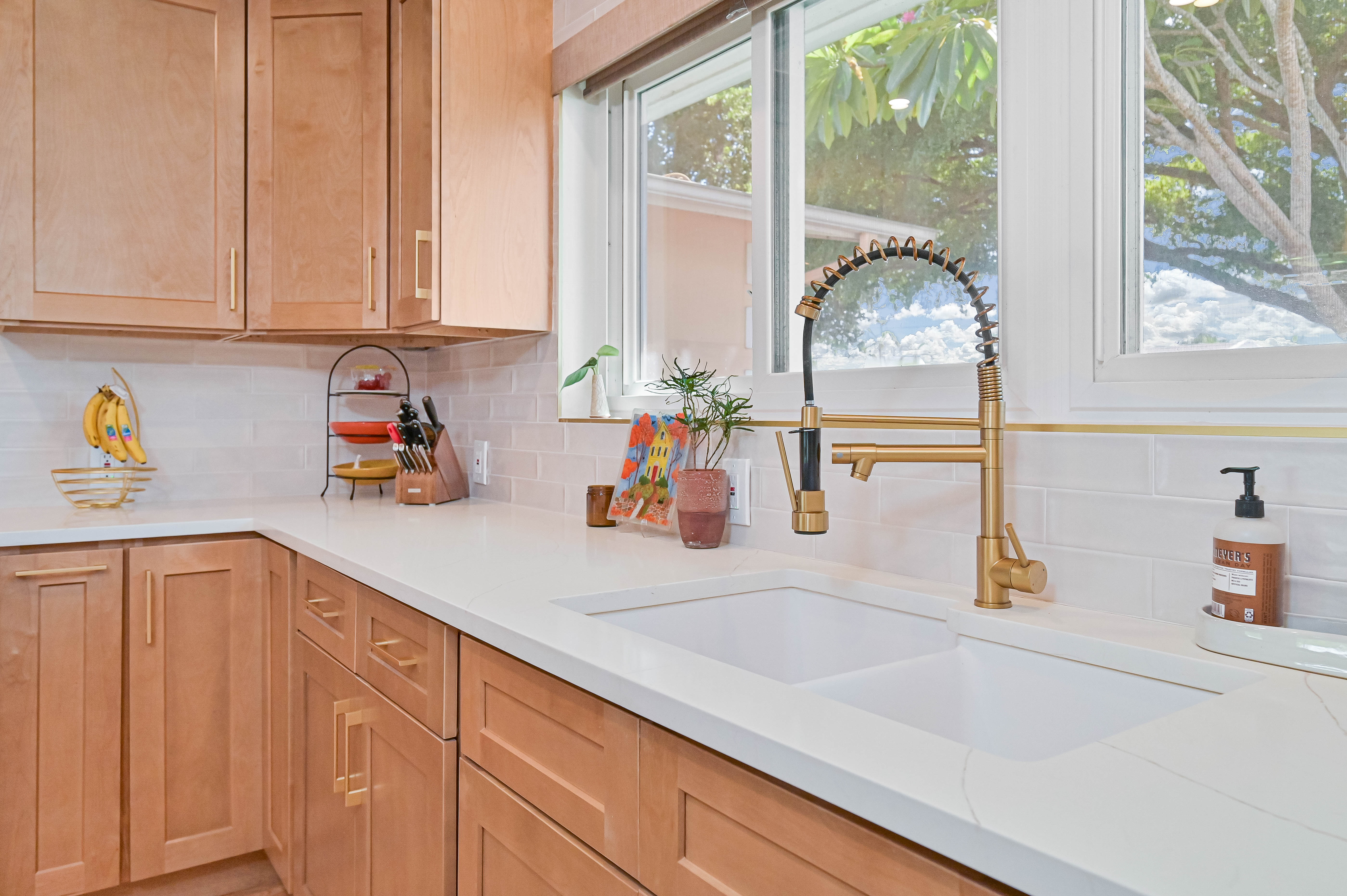 Schooner Bay Builders kitchen undermount sink with gold commercial spring faucet and warm cabinetry