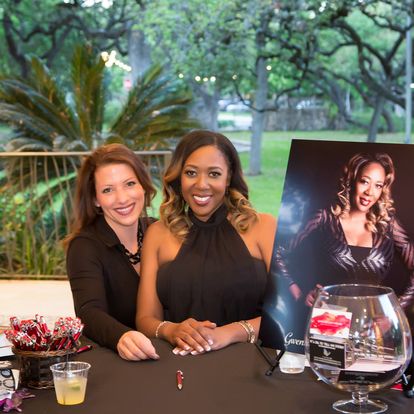 Gwendolen Wilder with guest at event table with portrait poster