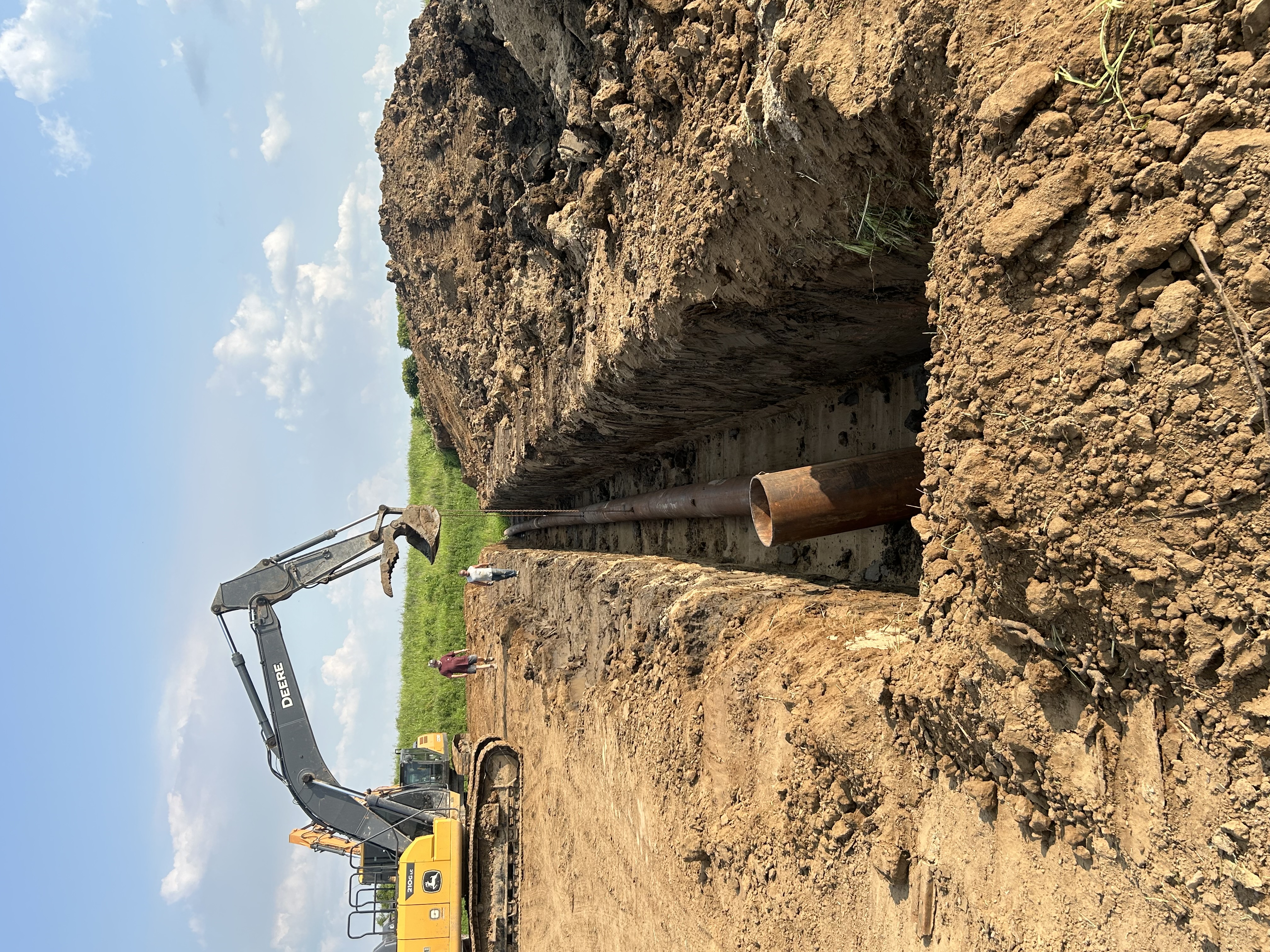 Excavator performing drainage work on regional farmland