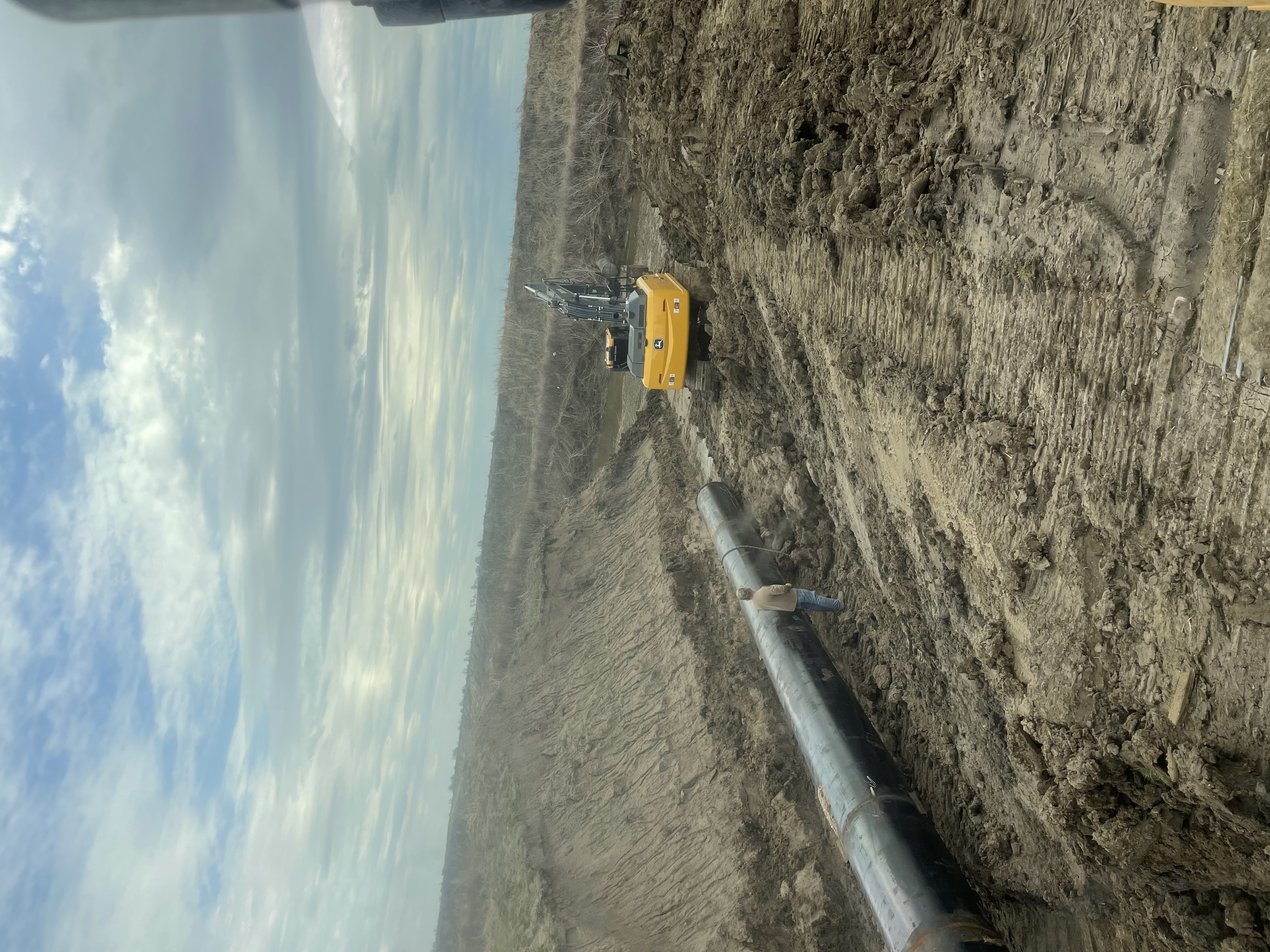 Excavator performing drainage work on rural land