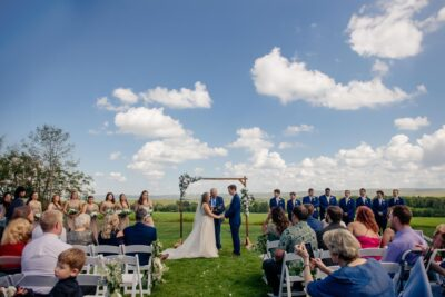 Spring outdoor wedding ceremony overlooking scenic Laurel Highlands countryside under bright blue sky