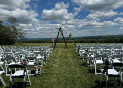 Outdoor ceremony lawn seating facing triangular wooden mountain arbors and sweeping sky