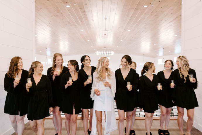 Bride and bridesmaids celebrating in robes on the upper bridal suite loft at The Willow