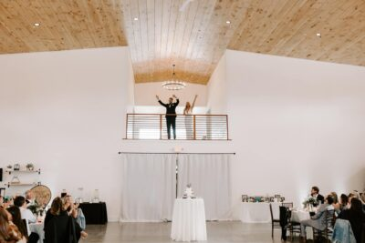 Bride and groom greeting wedding guests from the grand hall mezzanine balcony