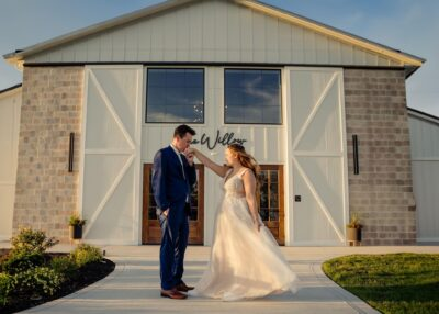 Bride and groom dancing outside The Willow venue entrance at golden hour