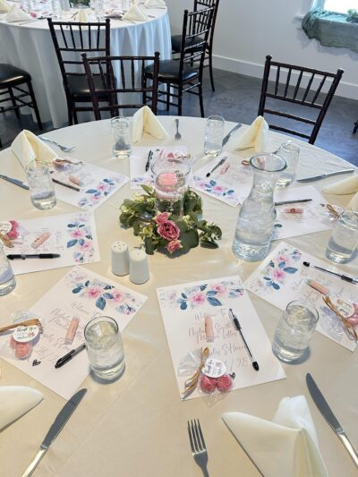 Elegant bridal shower place settings with custom floral stationery and party favors in the Side Room